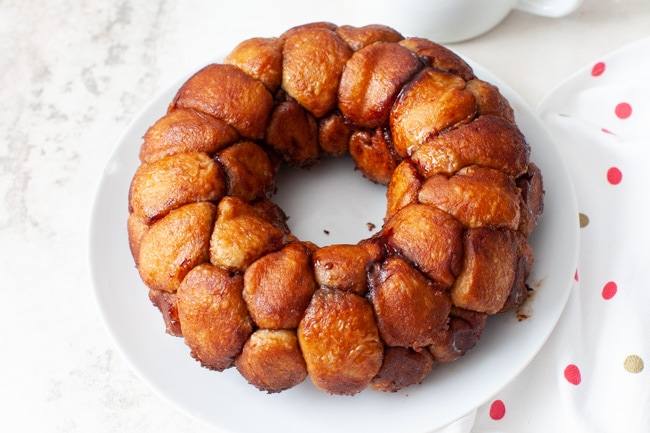 Easy Monkey Bread with Nutella from thelittlekitchen.net monkey bread on a plate with a napkin and a pitcher with frosting in the background