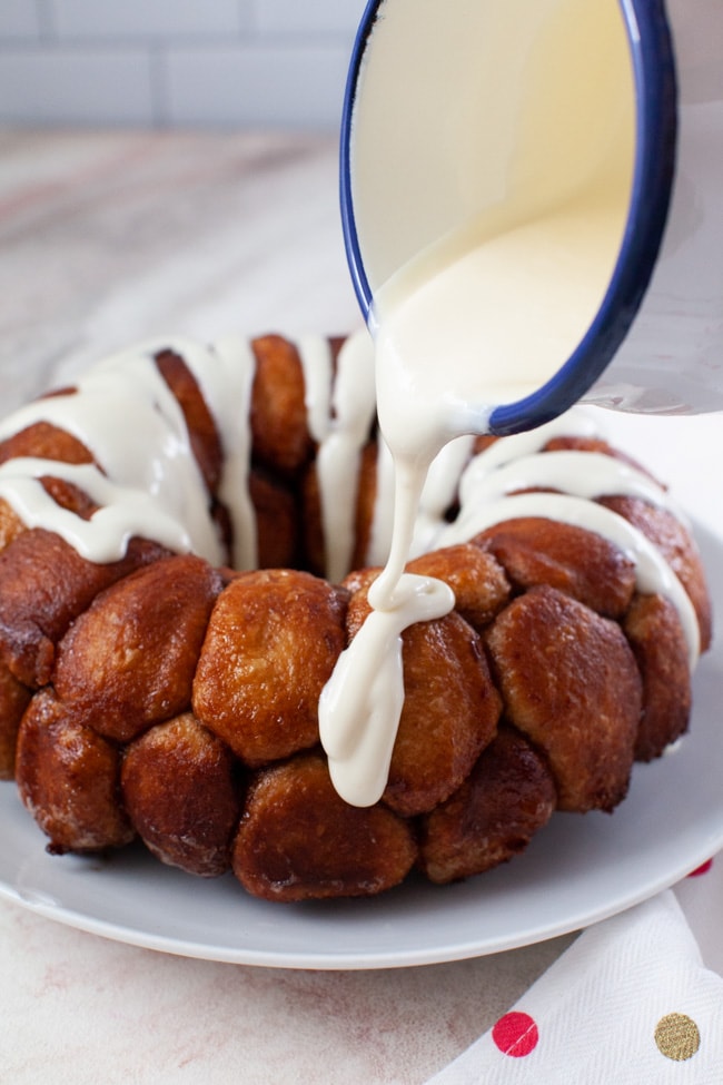 Easy Monkey Bread with Nutella from thelittlekitchen.net monkey bread on a plate with a napkin and a pitcher with pouring frosting