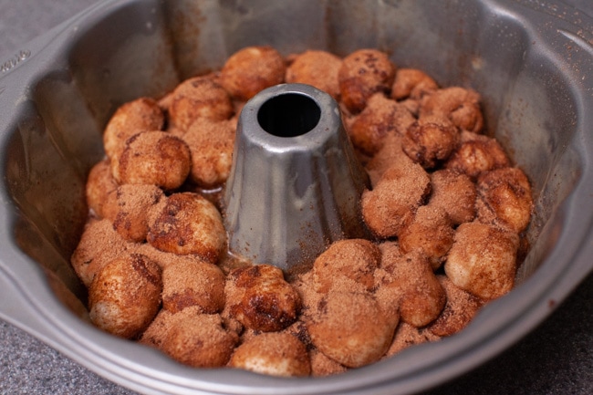 Easy Monkey Bread with Nutella from thelittlekitchen.net Monkey Bread dough in a bundt pan topped with butter and a cinnamon sugar mixture.