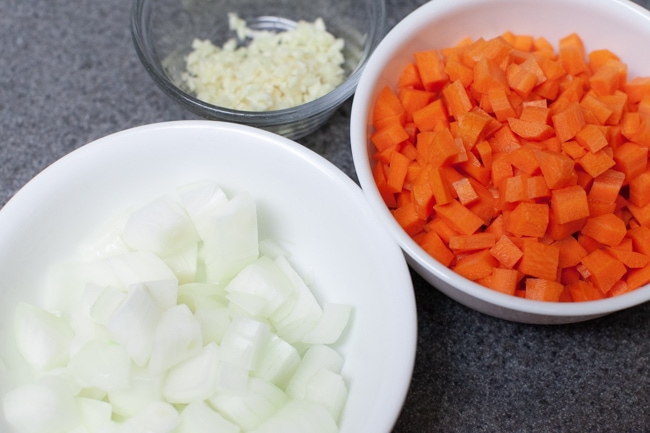 Instant Pot Tortellini Soup from thelittlekitchen.net Chopped onions in a white bowl, chopped carrots in a white bowl, and minced garlic in a small glass bowl.