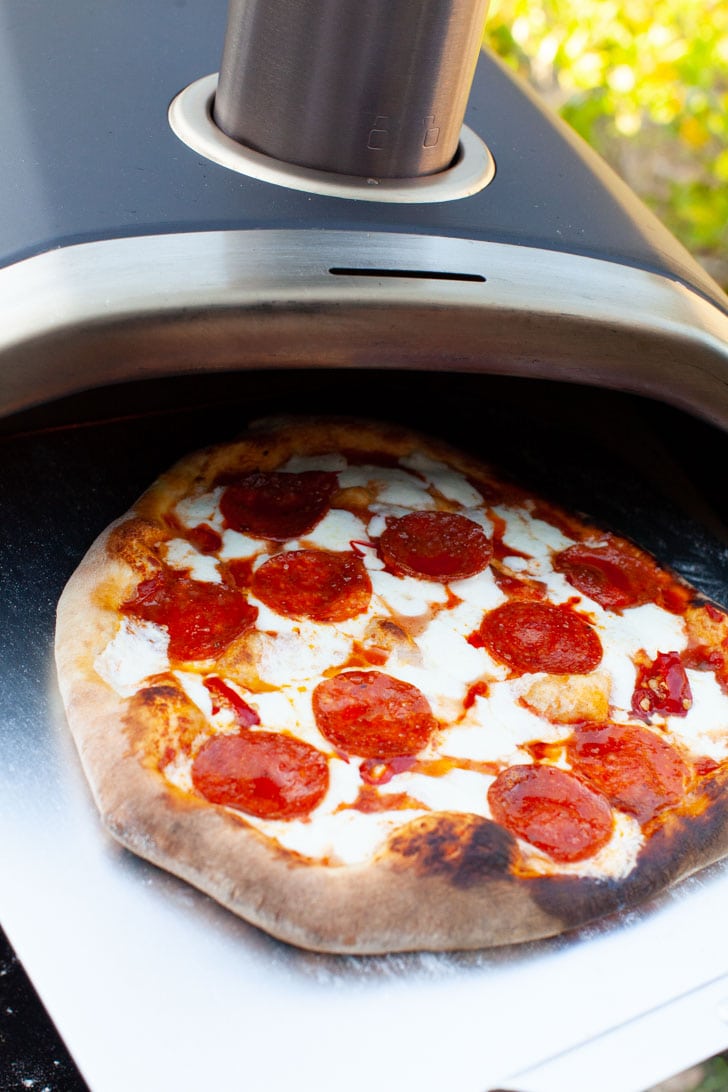 Making Pizza with Frozen Dough from thelittlekitchen.net Pepperoni Pizza on a pizza peel coming out of a Ooni pizza oven