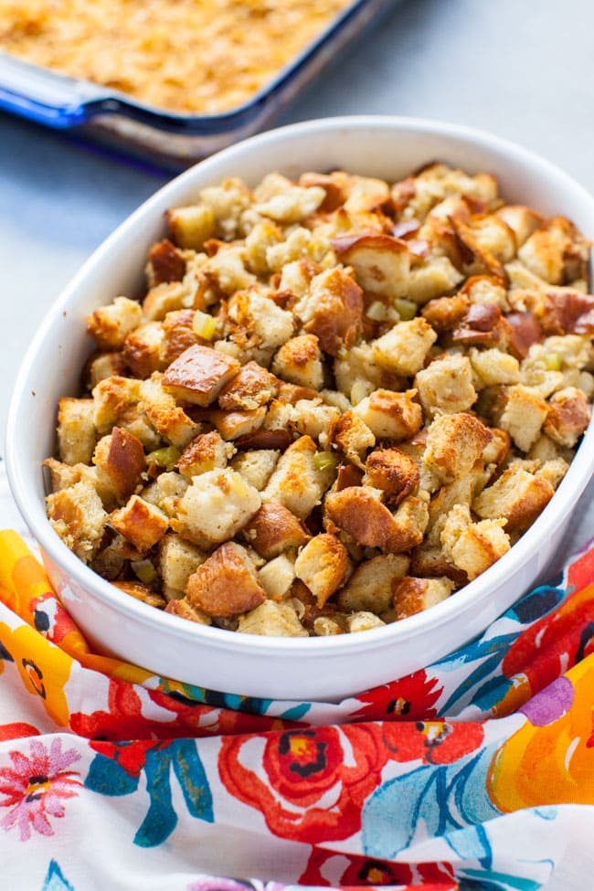 best stuffing recipe in a round baking dish with a colorful floral kitchen towel in the foreground