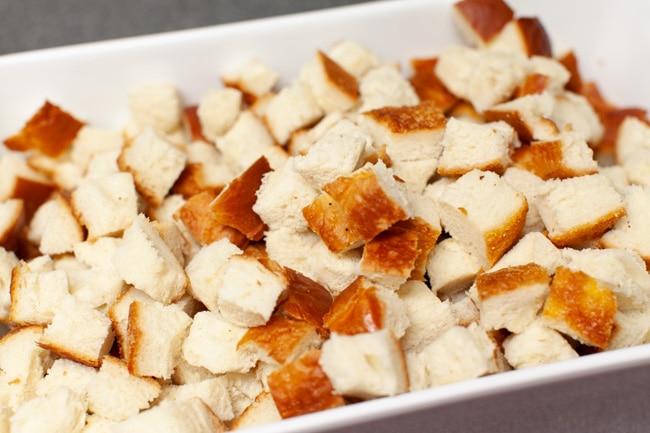 cut up bread in a white baking dish for best stuffing recipe