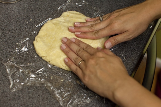 Hands pressing pie dough into circle Hands pressing pie dough into circle