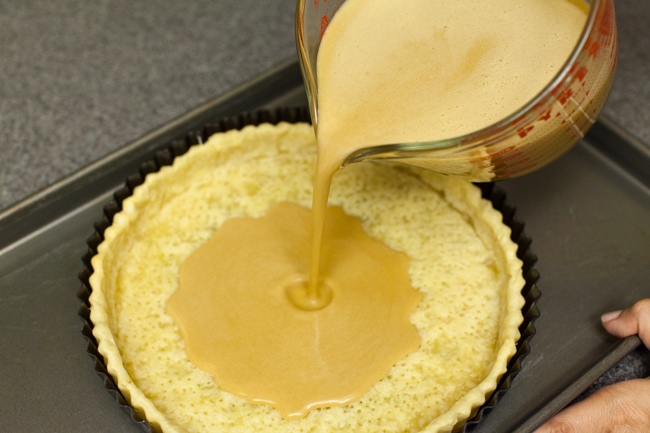 Pouring Sugar Pie filling into baked pie crust Pouring Sugar Pie filling into baked pie crust