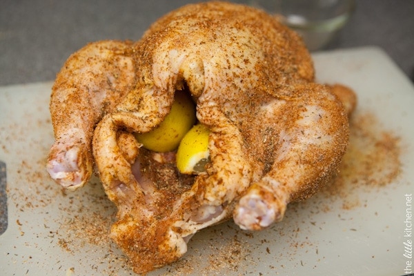 Whole Chicken in a Slow Cooker from TheLittleKitchen.net whole chicken on a cutting board with spice rub and stuffed with lemon