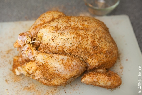 Whole Chicken in a Slow Cooker from TheLittleKitchen.net whole chicken tied with kitchen twine on a cutting board